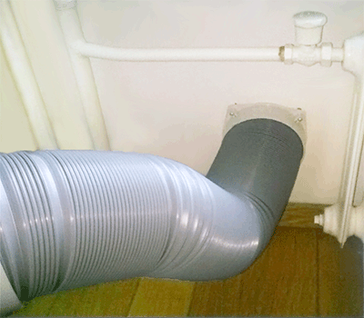 mobiele airco met slang door de muur