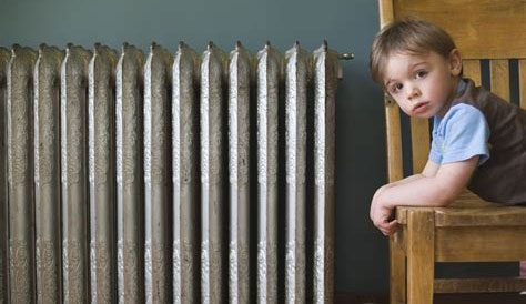 oude radiator met kind op stoel ernaast